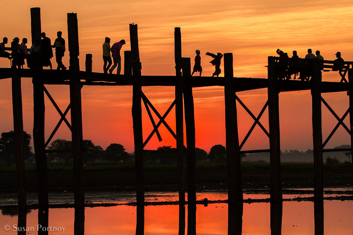 Stunning Silhouette Photos Guaranteed to Inspire Your Travels-Cut out from the background like paper dolls, travelers and locals cross the Ubein bridge in Mandalay, Myanmar