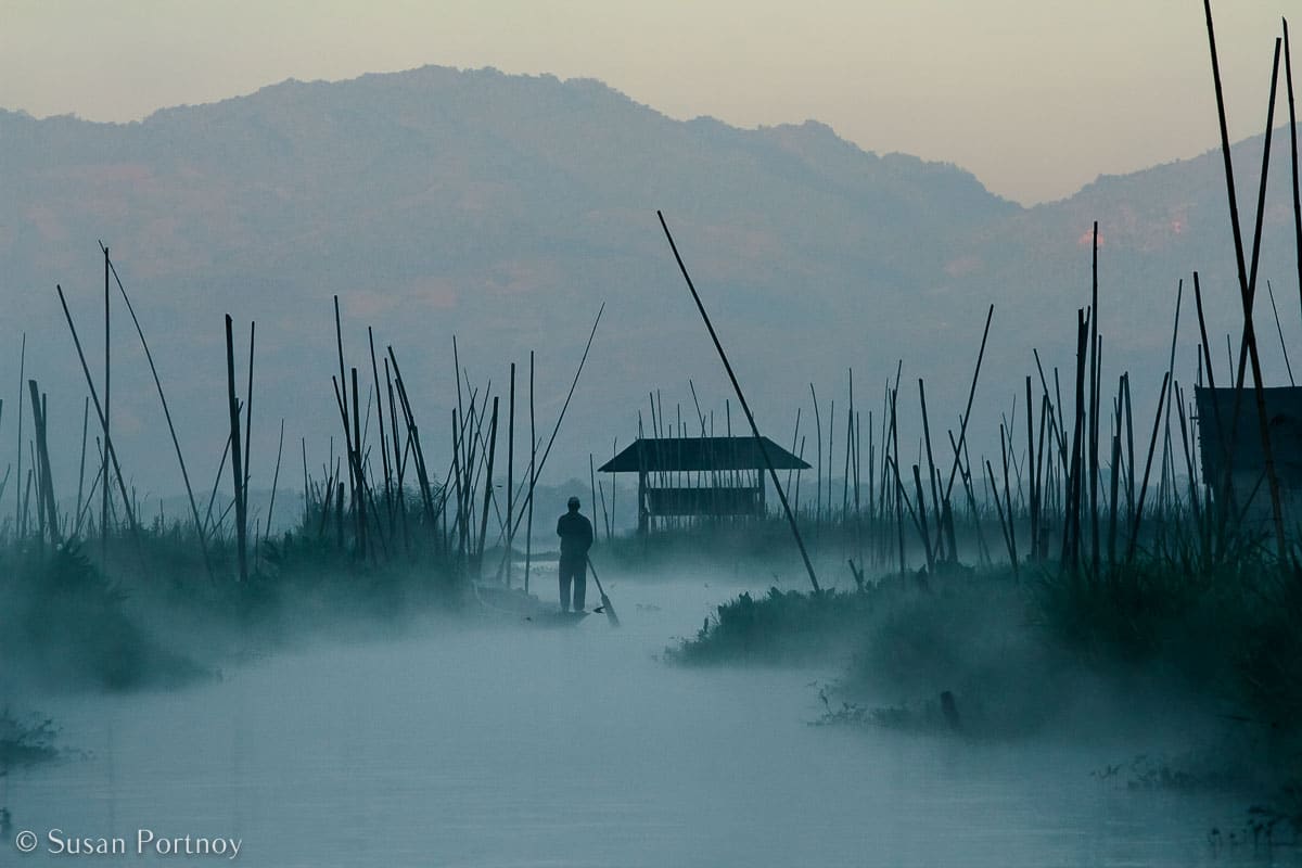 Stunning Silhouette Photos Guaranteed to Inspire Your Travels-A man paddles through the extensive floating gardens in front of our hotel, the Villa Inle, on Inle lake in Myanmar.