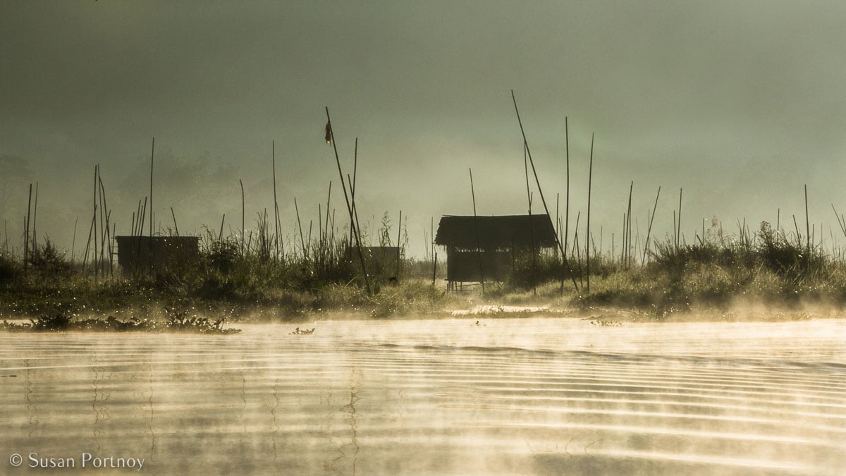 Stunning Silhouette Photos Guaranteed to Inspire Your Travels-Beautiful, misty view of floating garden with a gardener's hut, on Inle Lake in Myanmar.